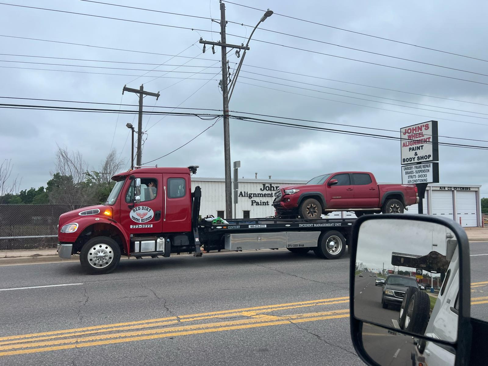 Brown & Sons flatbed tow truck carrying a pickup truck on the road in Shawnee, Oklahoma