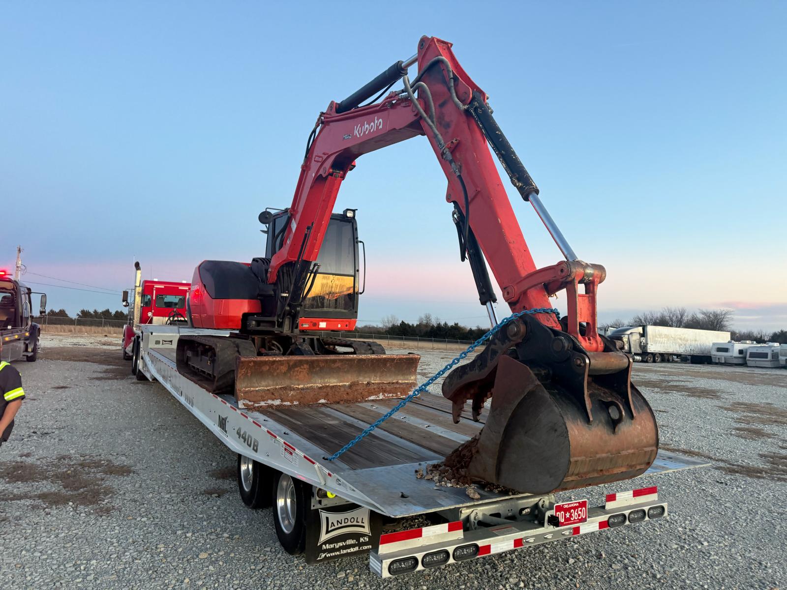 Kubota excavator chained to the Brown & Sons Landoll flatbed for heavy equipment hauling