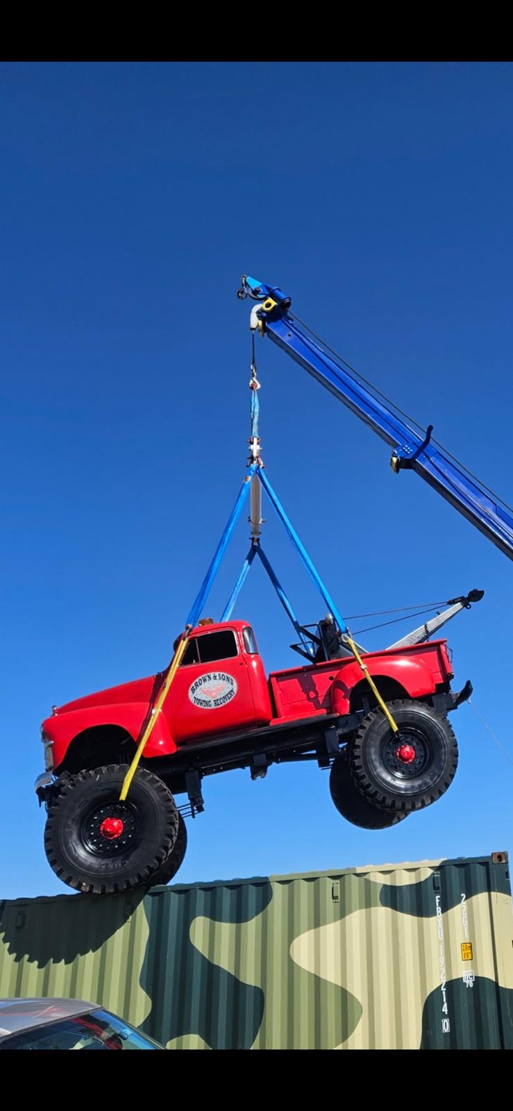 Brown & Sons vintage wrecker truck being lifted by crane